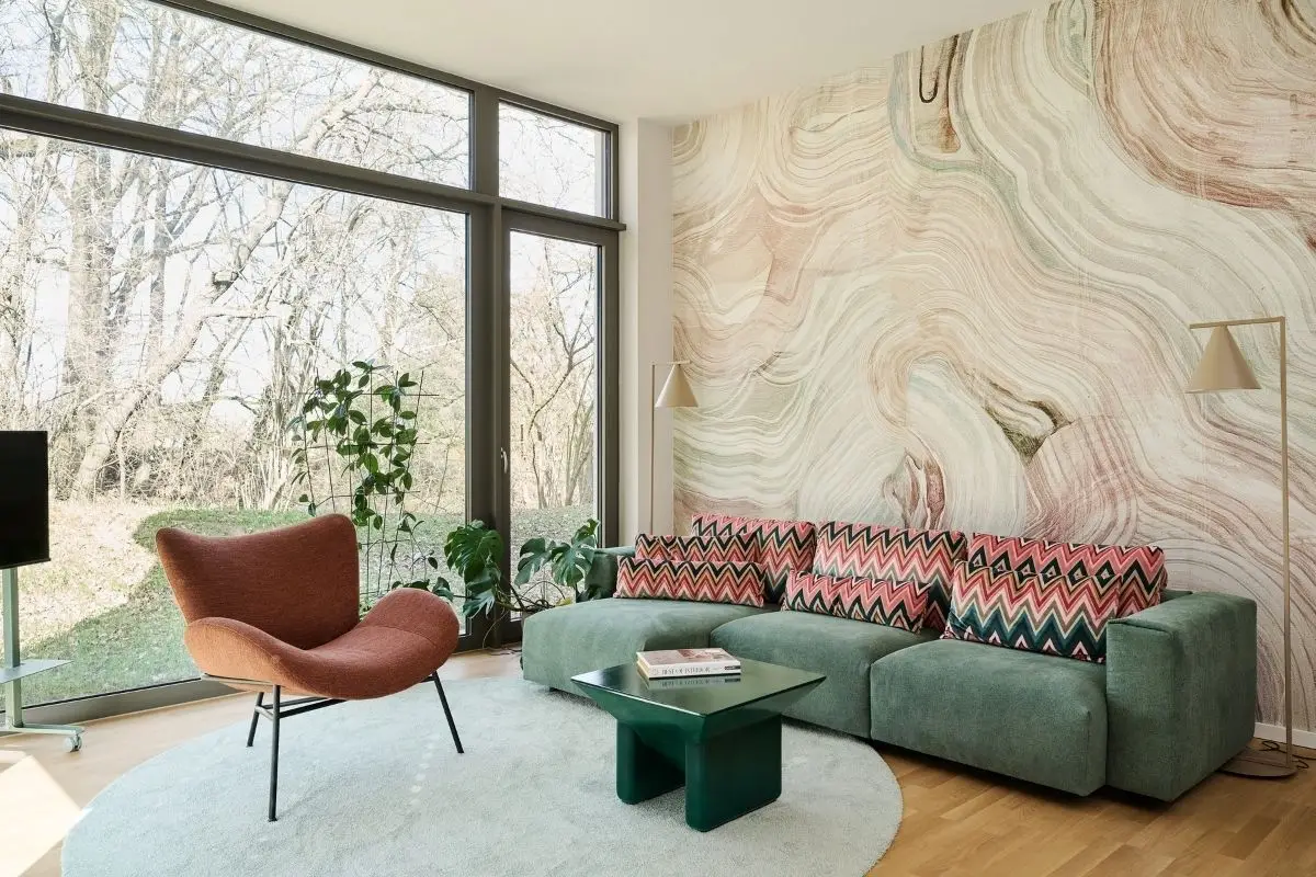 Wohnzimmer mit grünem Sofa und Marmor-Wandtapete in einer Einliegerwohnung in Fulda